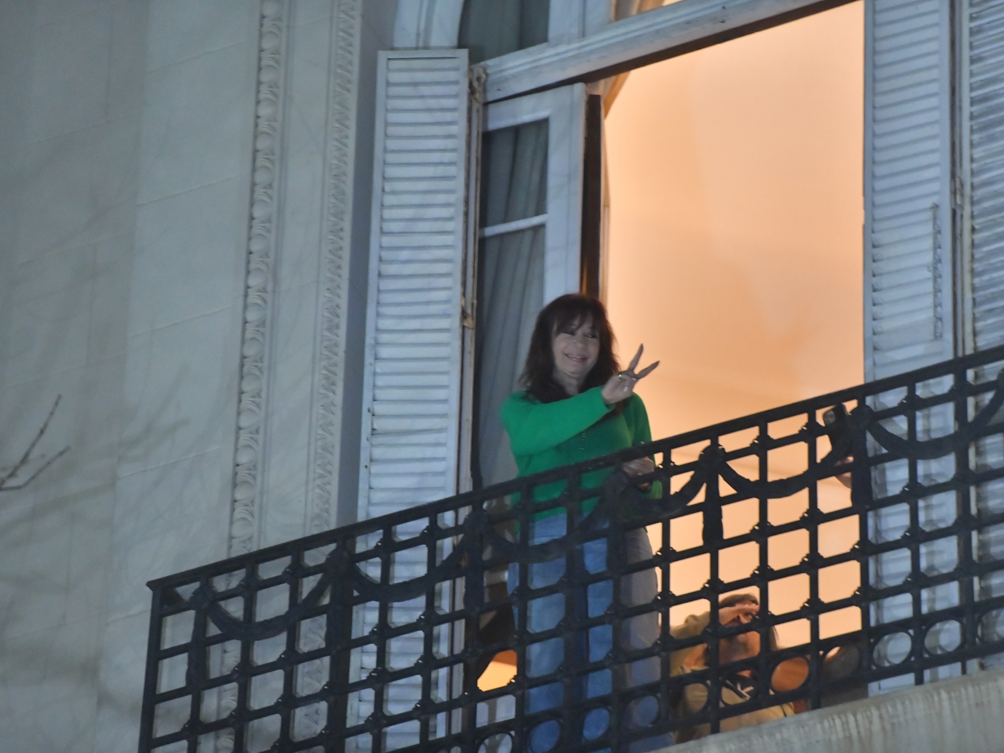 Bol pantolon giyen ve ilk kez resmi olarak tanınan Cristina Kirchner, elektronik ayak bileği bilekliği takarak balkona çıktı.